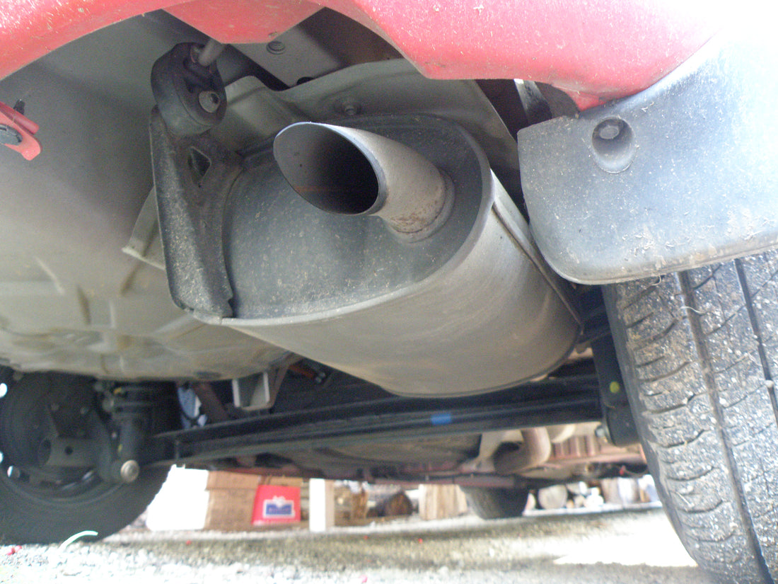 Car exhaust muffler, tailpipe and rear undercarriage; general exhaust illustration for the Dynofit EGR kit guide, not an installed product photo
