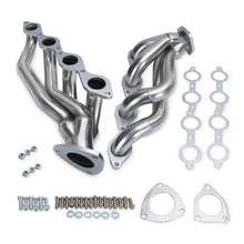 Set of stainless steel exhaust pipes with gaskets and hardware on a white background